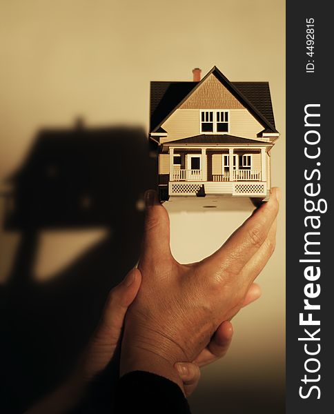 Human hands holding a model of a house, shallow DOF. Human hands holding a model of a house, shallow DOF