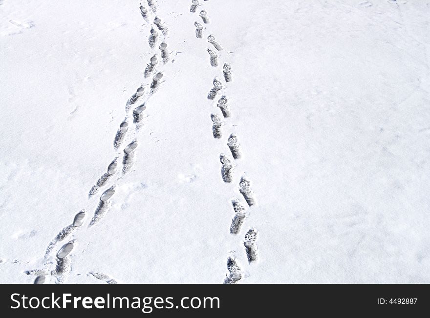 Two rows of footsteps on snow background