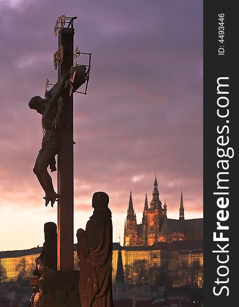 Jesus Christ statue on Charles Bridge in Prague with Prague Castle in the background. Jesus Christ statue on Charles Bridge in Prague with Prague Castle in the background