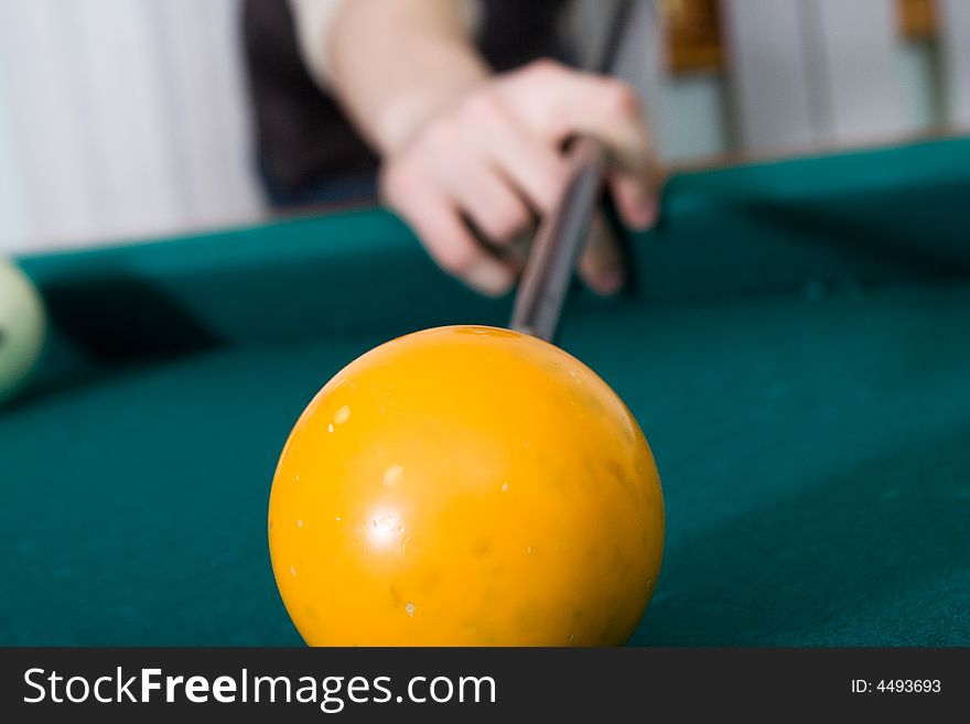 The guy plays billiards (focus on ball)