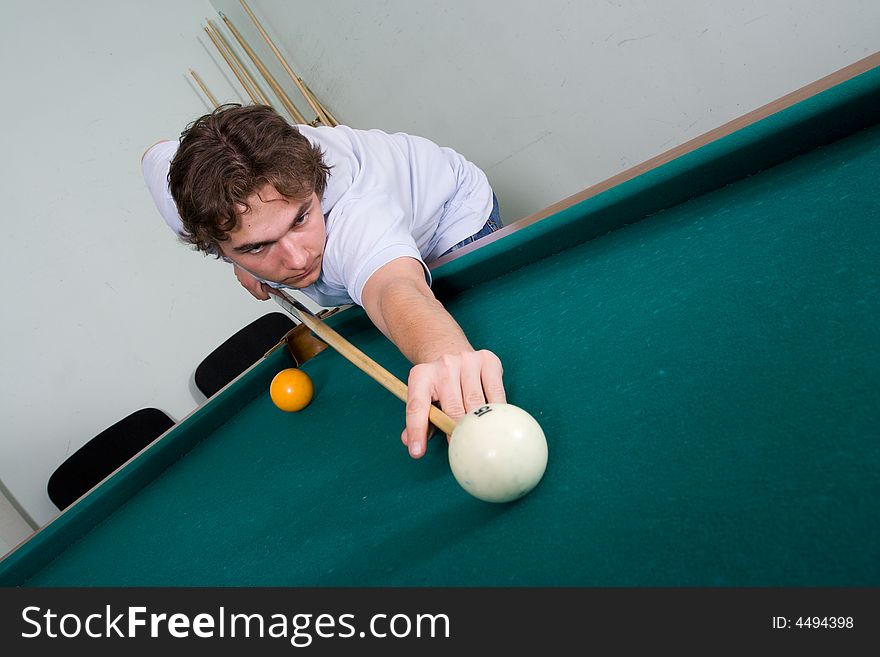 The young guy plays billiards. The young guy plays billiards