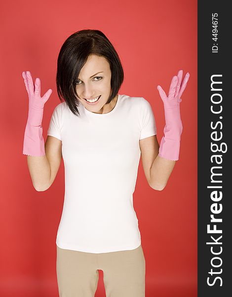 Young woman in pink rubber gloves holding in hand washcloth. She's looks like very angry. Looking at camera, front view. Young woman in pink rubber gloves holding in hand washcloth. She's looks like very angry. Looking at camera, front view.