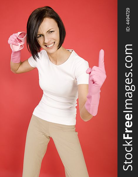 Young woman in pink rubber gloves holding in hand washcloth and threateningly finger. She's looks like very angry. Looking at camera, front view. Young woman in pink rubber gloves holding in hand washcloth and threateningly finger. She's looks like very angry. Looking at camera, front view.