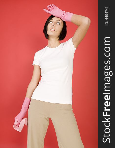 Young woman in pink rubber gloves holding in hand washcloth. She's looks like exhausted. Front view. Young woman in pink rubber gloves holding in hand washcloth. She's looks like exhausted. Front view.