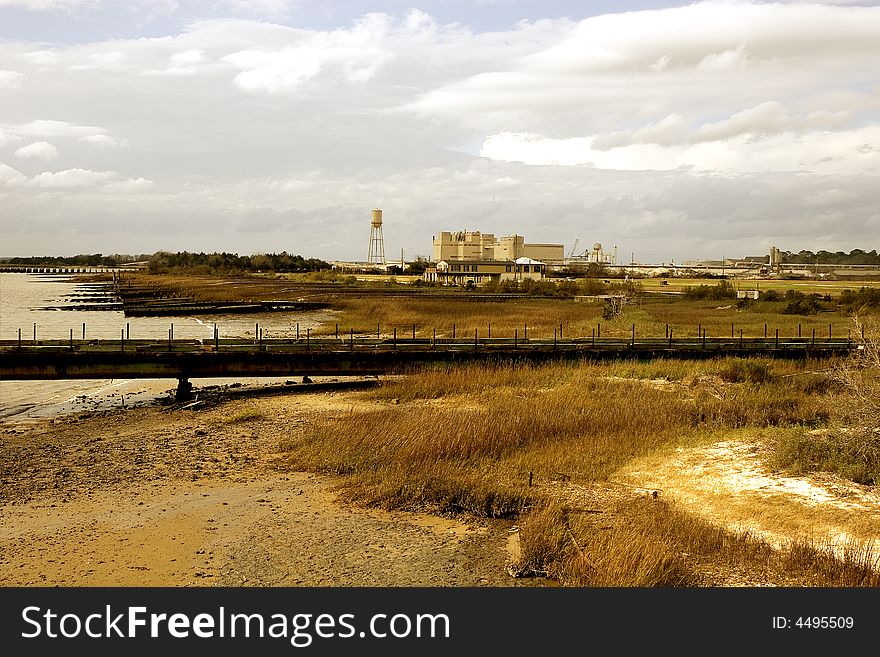 An industrial structure on the coast between wetlands and the bay. An industrial structure on the coast between wetlands and the bay