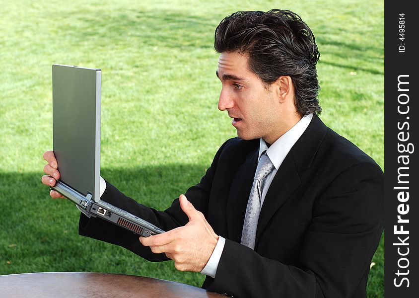 Shocked and suprised businessman looking at his laptop