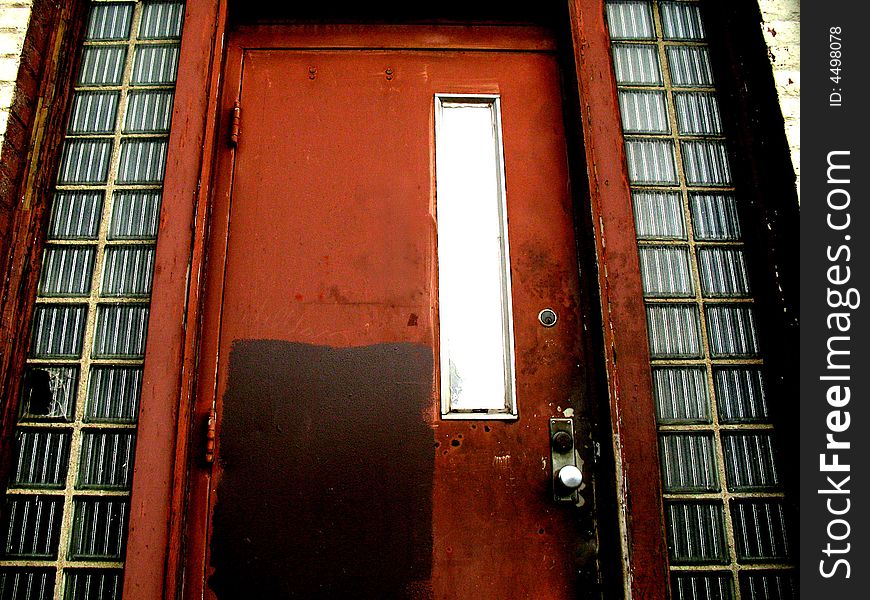 Dilapidated red door to an abandoned office building. Dilapidated red door to an abandoned office building