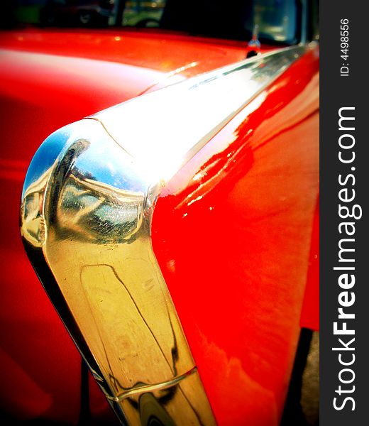 Close up of the chrome tail fin of a red vintage car