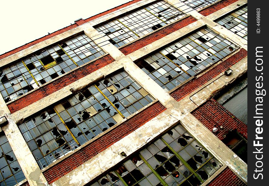 Broken windows framed by brick walls at an abandoned factory