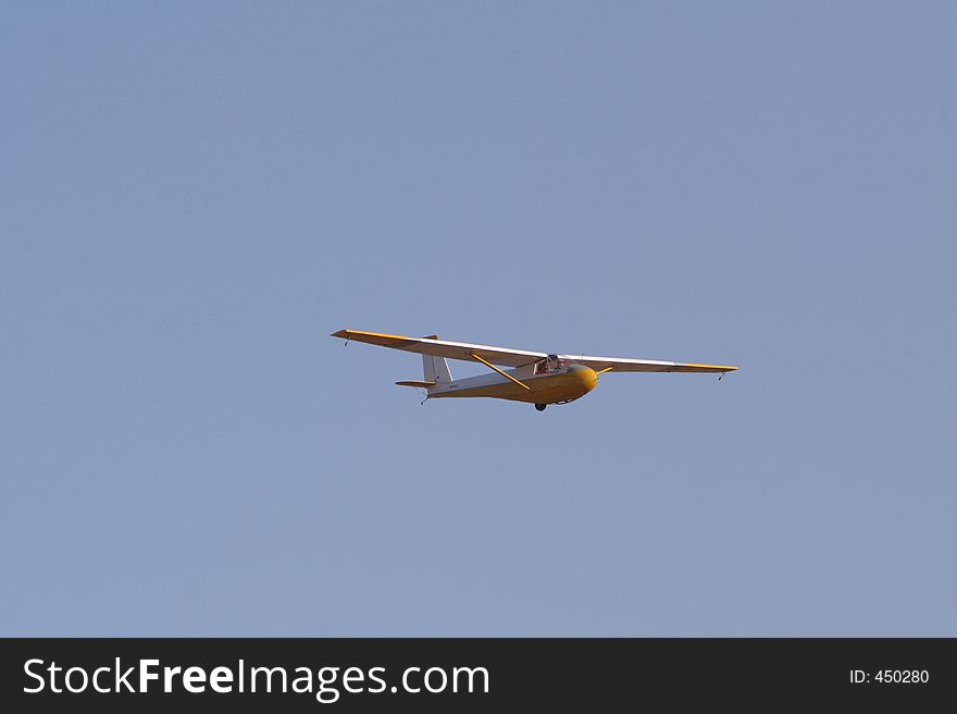 Yellow glider in blue sky