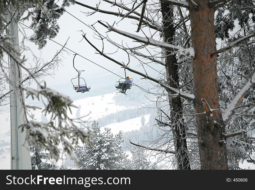 Snowboarder riding uphill. Snowboarder riding uphill