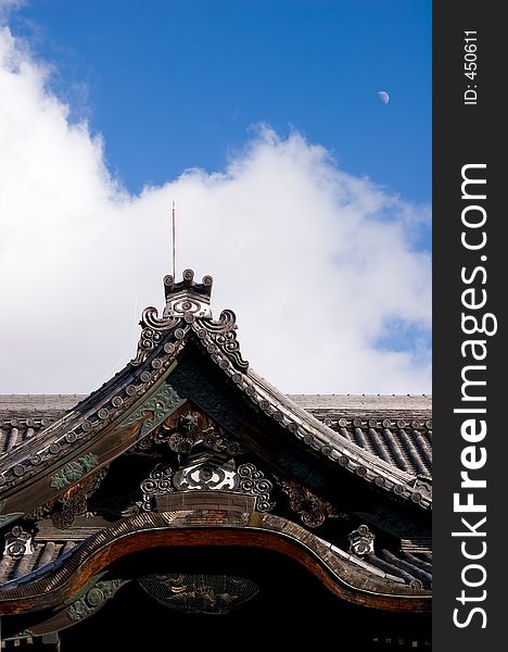 Peak of a temple in Kyoto, Japan with bright blue sky in background and daylight view of moon. Peak of a temple in Kyoto, Japan with bright blue sky in background and daylight view of moon.