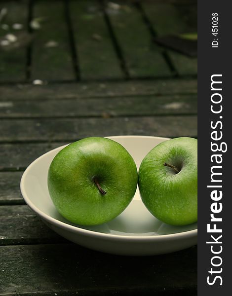 Green apples on a white plate