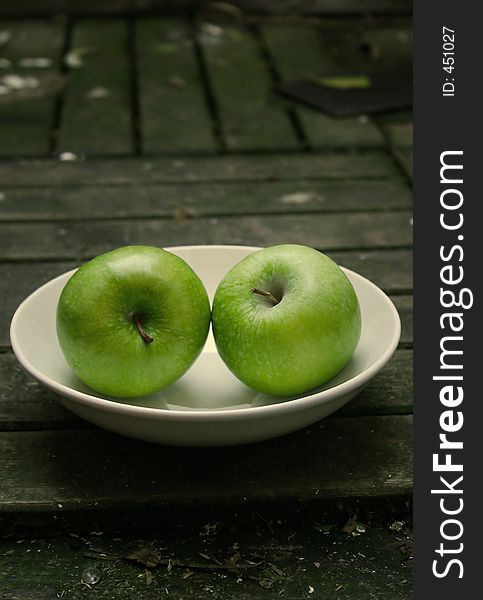 Green apples on a white plate