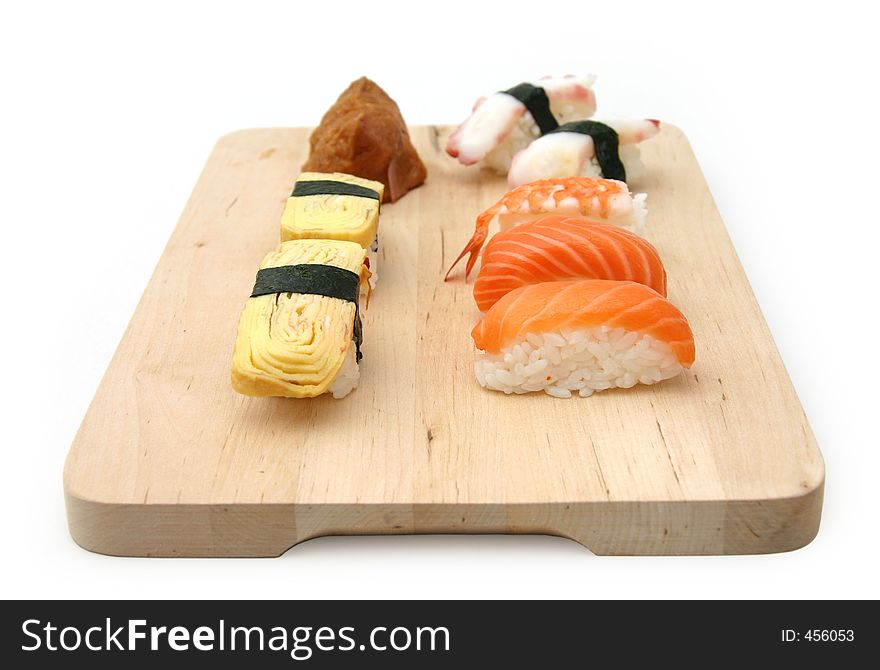 A selection of sushi served on a wooden surface board