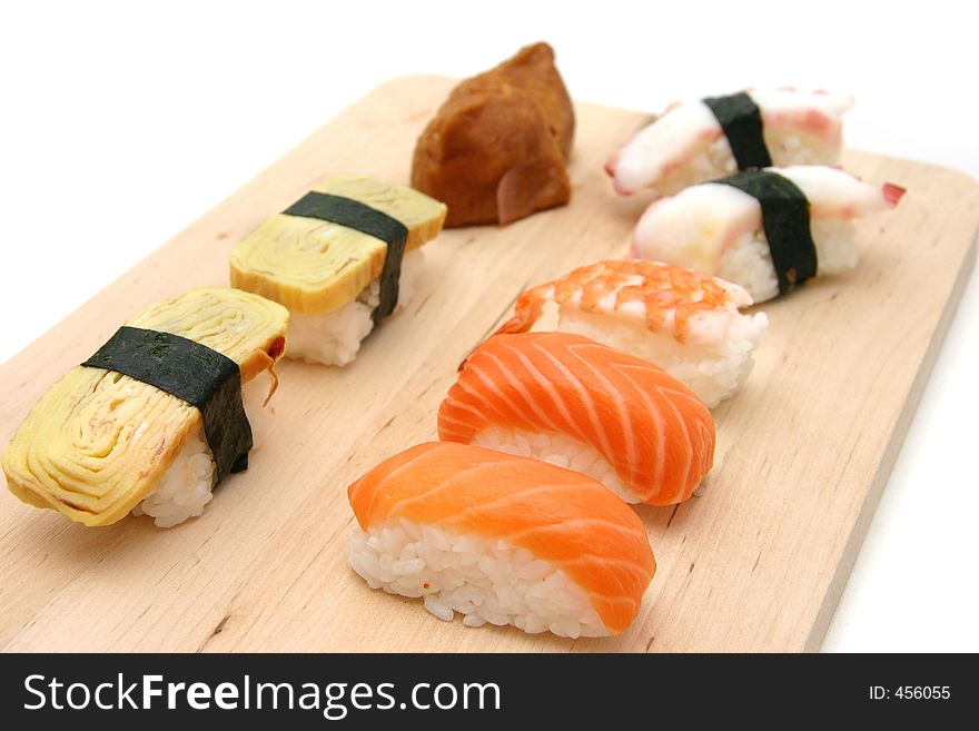 A selection of sushi served on a wooden surface board