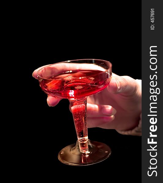 A glass of rose shampagne in hand isolated on black. A glass of rose shampagne in hand isolated on black