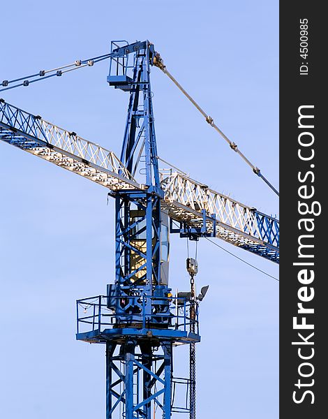 A blue and white crane at a construction site