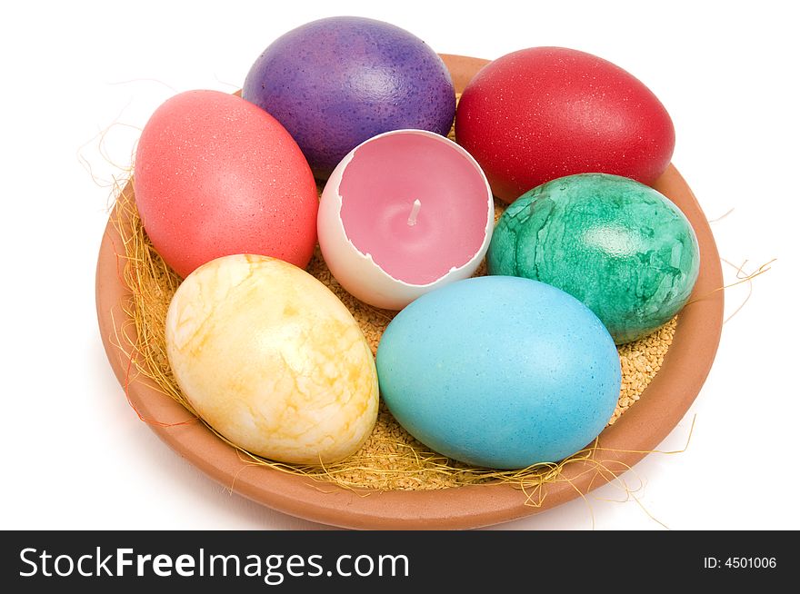 Easter colored eggs with candle on a plate. Easter colored eggs with candle on a plate.