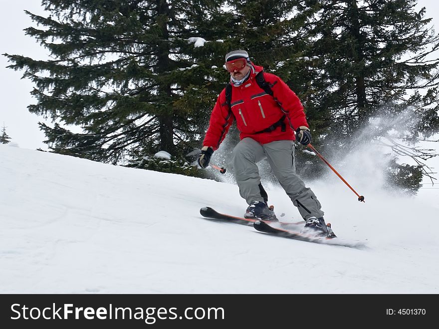 Skier moving down hill at high speed on winter resort
