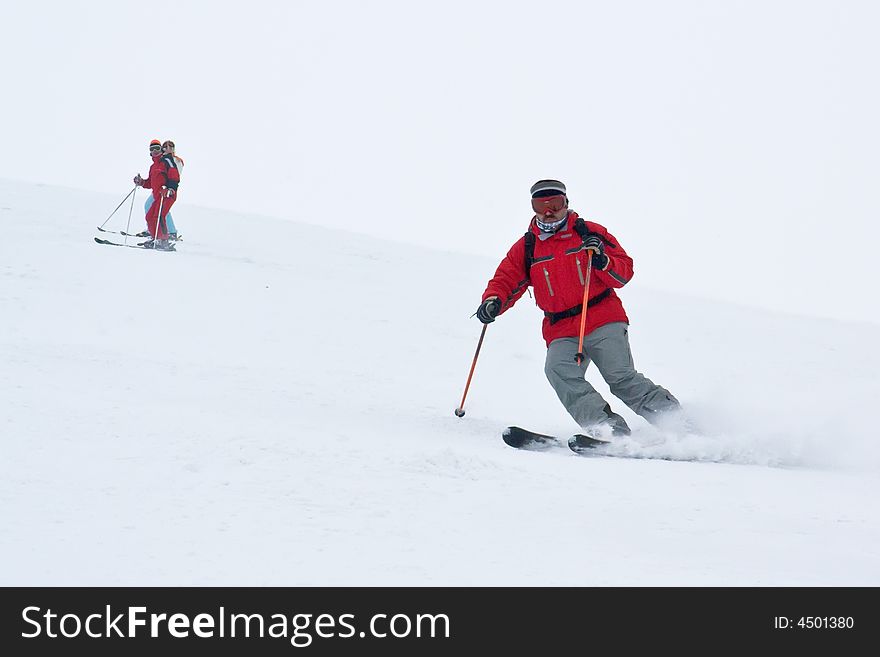 Man alpine skier running down fast on European winter resort