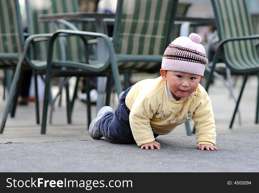 A little boy is climbing on the floor.