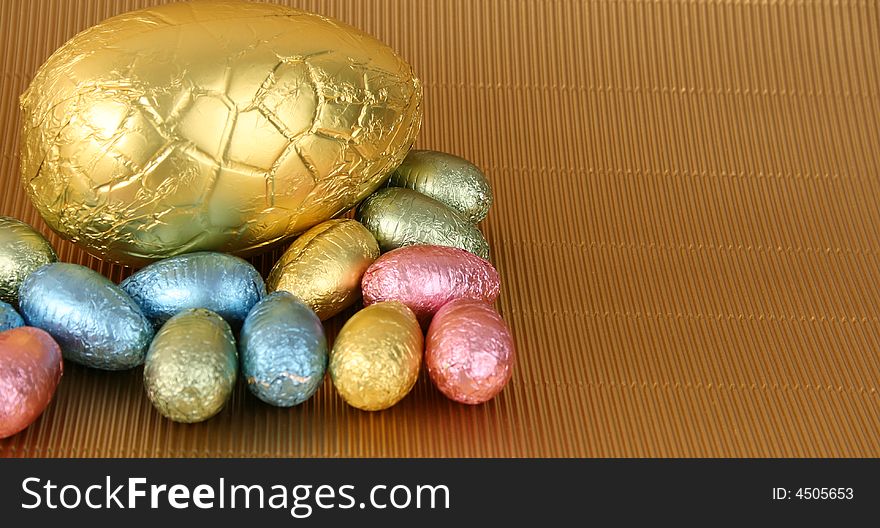 Various colors and shaped easter eggs on a gold background