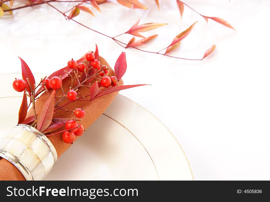 Decorative cloth napkin in napkin ring with red and orange leaves and berries. Decorative cloth napkin in napkin ring with red and orange leaves and berries