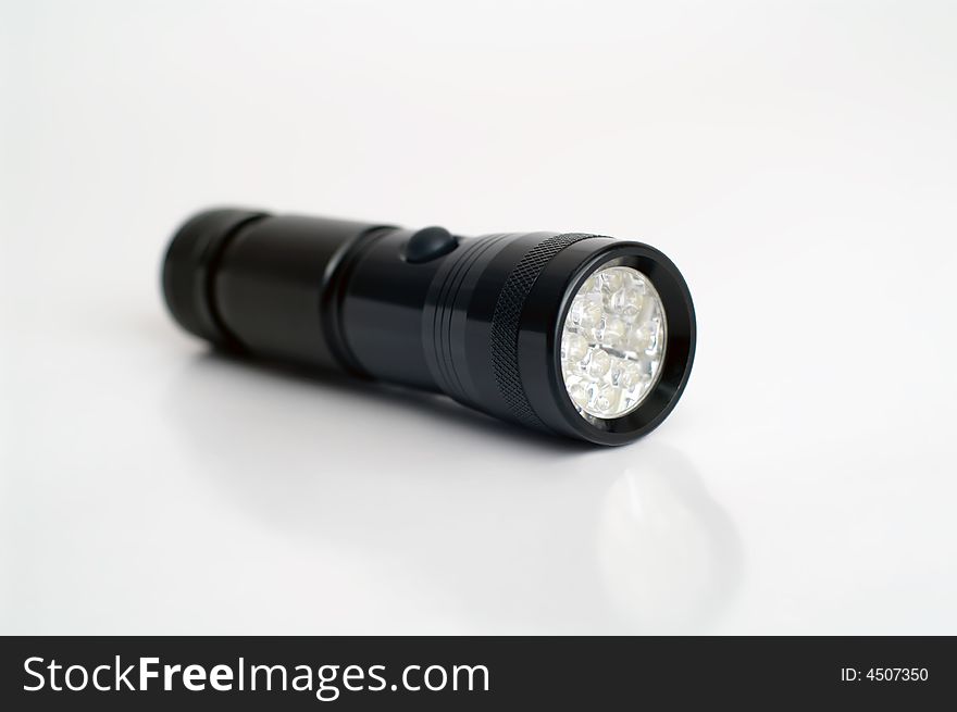 Black pocket flashlight on white