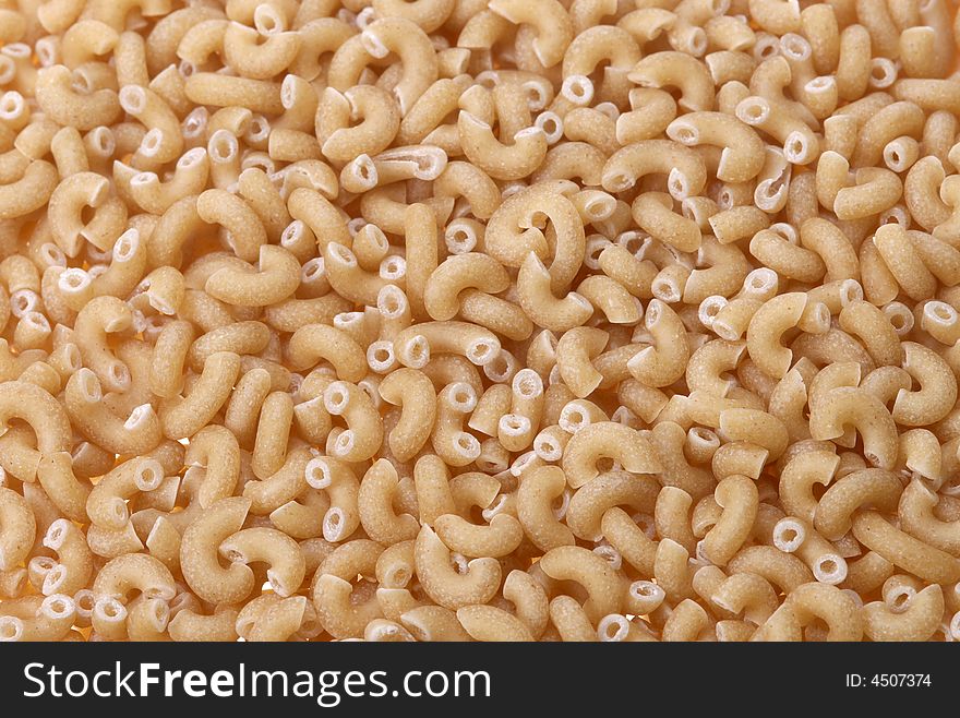 Close-up of whole wheat macaroni pasta for backgrounds. Close-up of whole wheat macaroni pasta for backgrounds