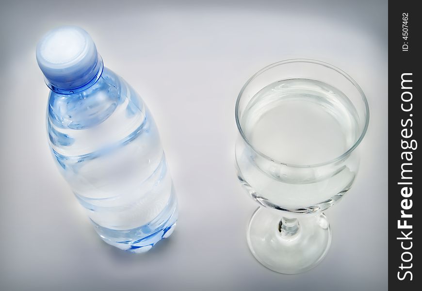 Bottle of water and glass on a white background