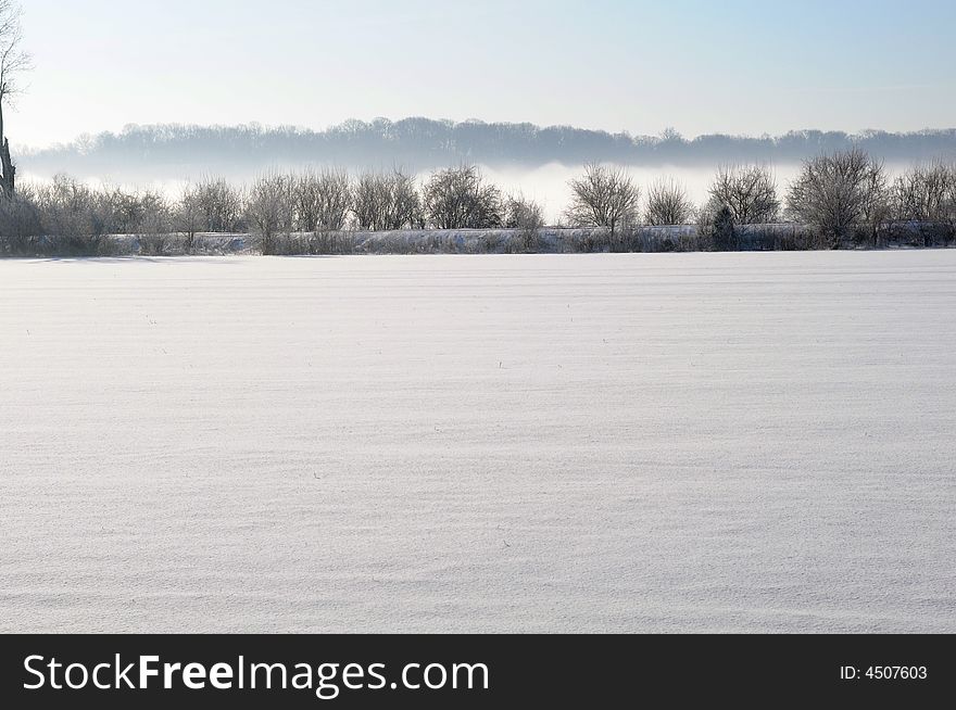 Frozen landscape with fog in distant hills