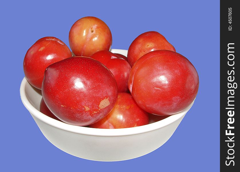 A close up of a bowl of plums