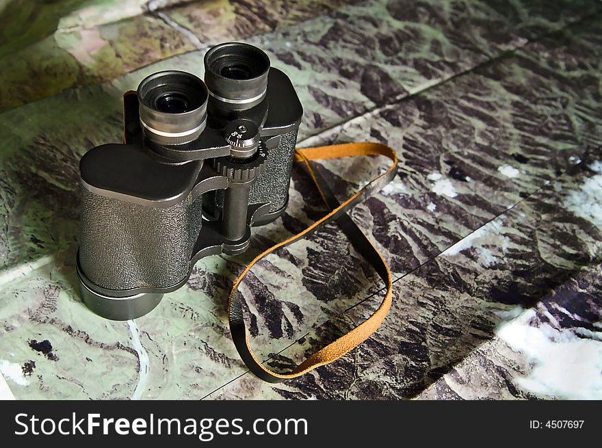 Black binoculars on photo map. Black binoculars on photo map