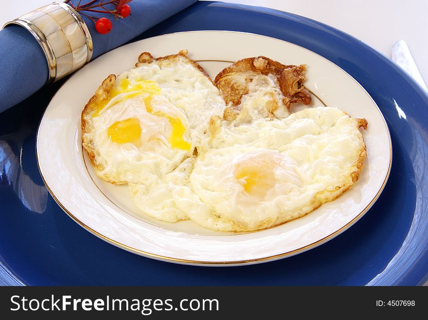 Fried Eggs on white and blue table setting
