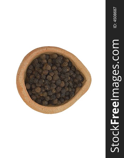 Black pepper in the plate isolated over white