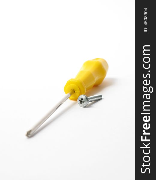 Yellow screwdriver with  silver screw in a white background