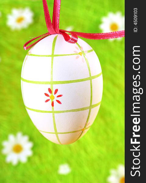 Pastel and colored Easter egg on green