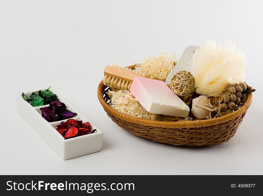 Personal care items and decorations in a basket isolated on white background.