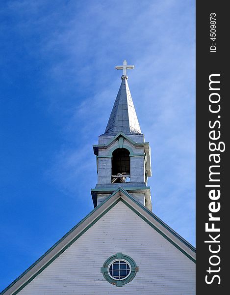 Church steeple against a blue sky, reflecting sunlight. Church steeple against a blue sky, reflecting sunlight