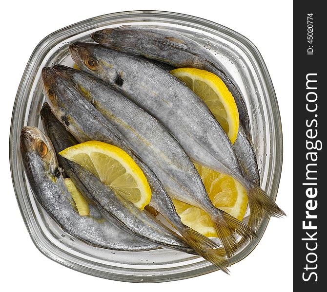 Selar kuning fish with slices of lemon in a transparent glass bowl isolated on white background