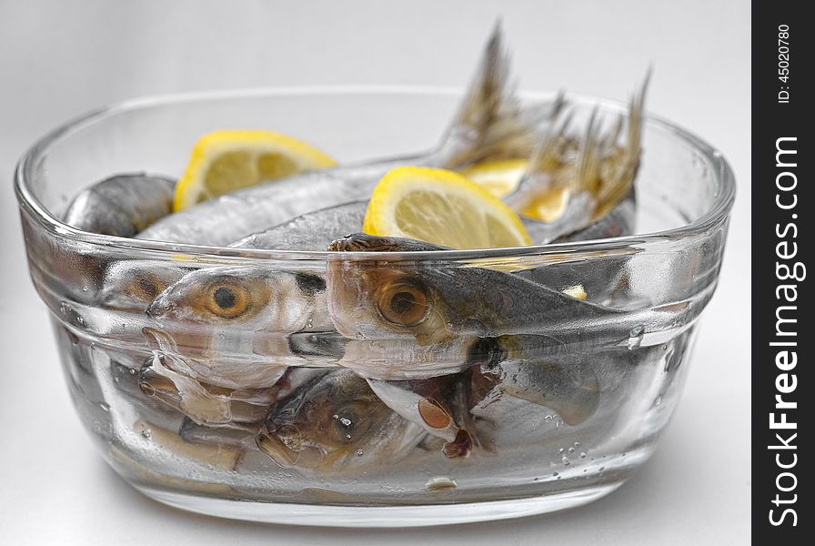Selar kuning fish with slices of lemon in a transparent glass bowl