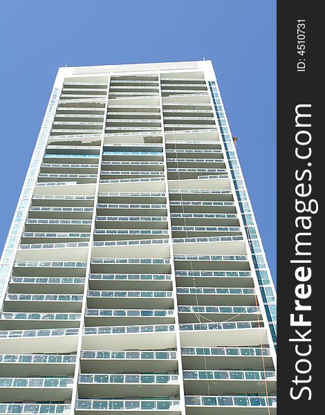 Modern abstract condominium building on a blue sky. Modern abstract condominium building on a blue sky