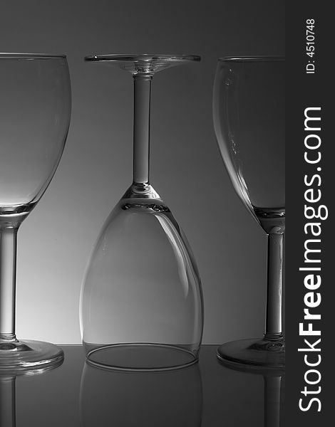 Three white wine glasses on gradiented background. Three white wine glasses on gradiented background