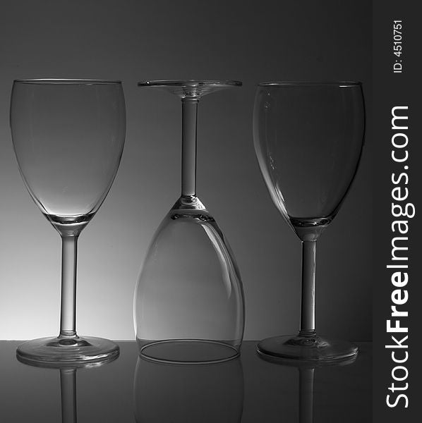 Three white wine glasses on gradiented background. Three white wine glasses on gradiented background