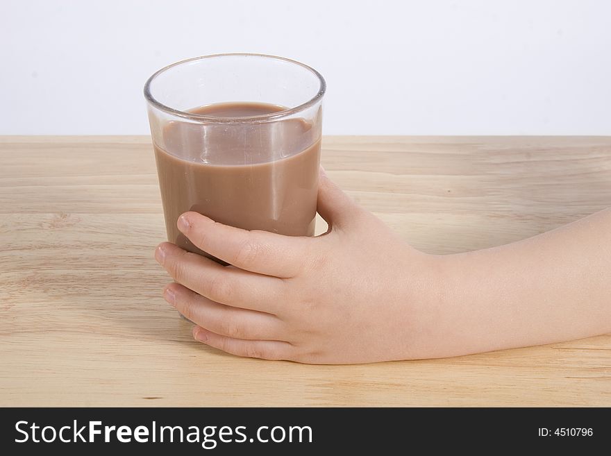 A hand with a glass milk chocolate