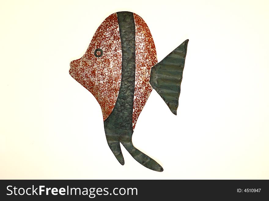 Rust and white and green patterned fish crafted from metal isolated against white background. Rust and white and green patterned fish crafted from metal isolated against white background