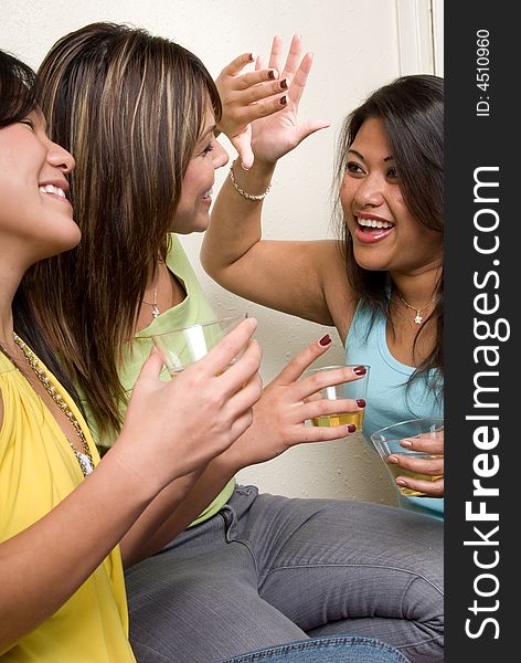 Two girls giving each other high five as the other girl smiles. Two girls giving each other high five as the other girl smiles.