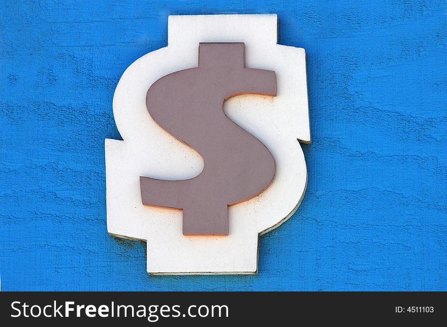 Wooden cut out dollar sign at a carnival against a blue background. Wooden cut out dollar sign at a carnival against a blue background