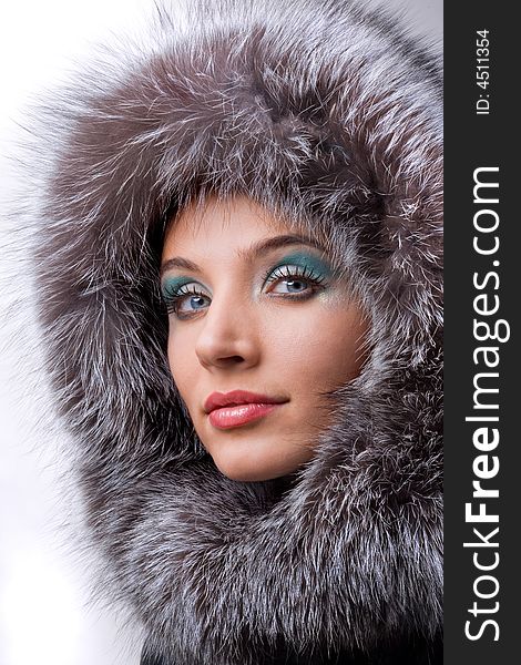 Beautiful young woman with a fur hood